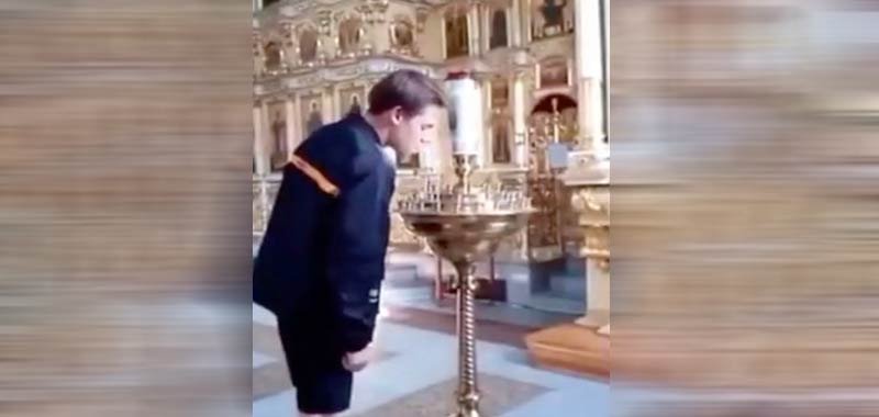 Accende una sigaretta sulle candele liturgiche della chiesa