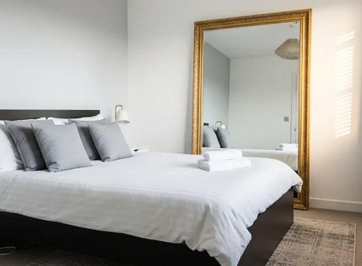 Una camera da letto elegante con un grande specchio antico di fronte al letto