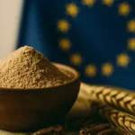 Bandiera Unione Europea accanto a un grillo e una ciotola di farina di grillo