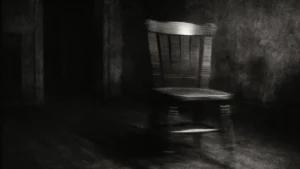 Fotografia sgranata di una sedia che si muove da sola in una stanza