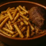 Piatto di ziti conditi con ragù alla genovese napoletana